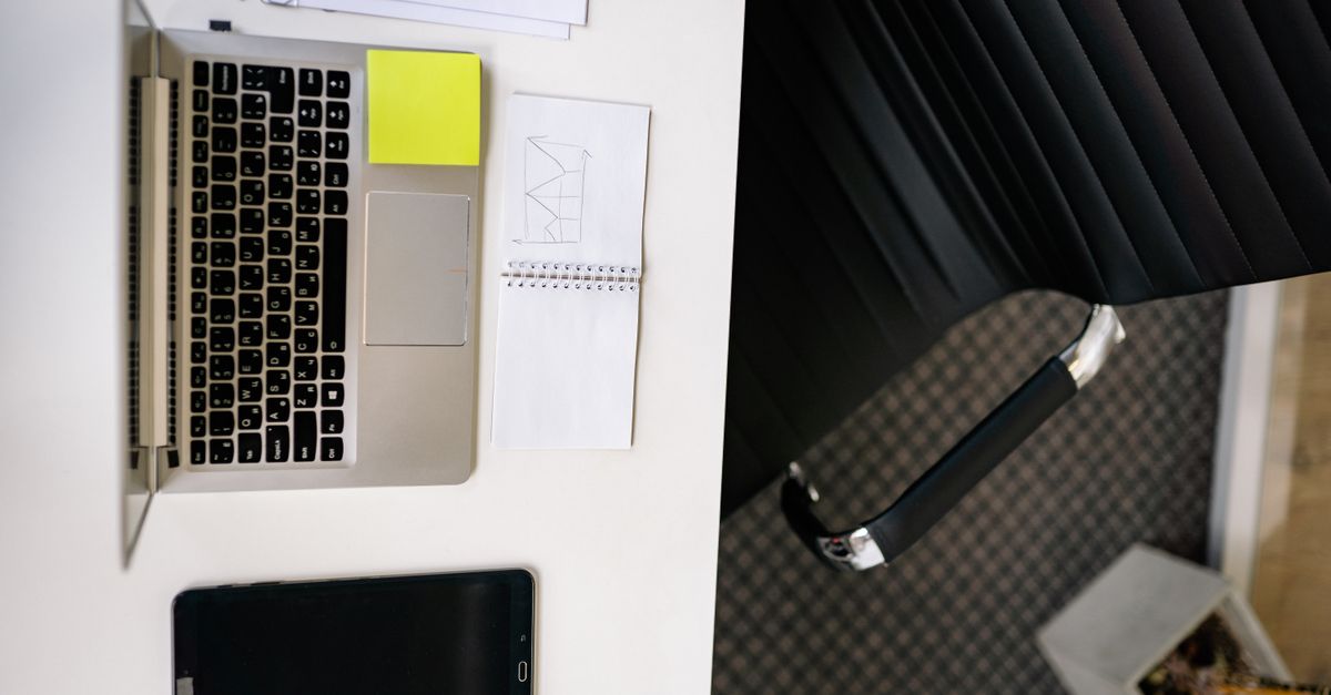 Top view of a neat office desk with a laptop and tablet, creating a modern workspace.